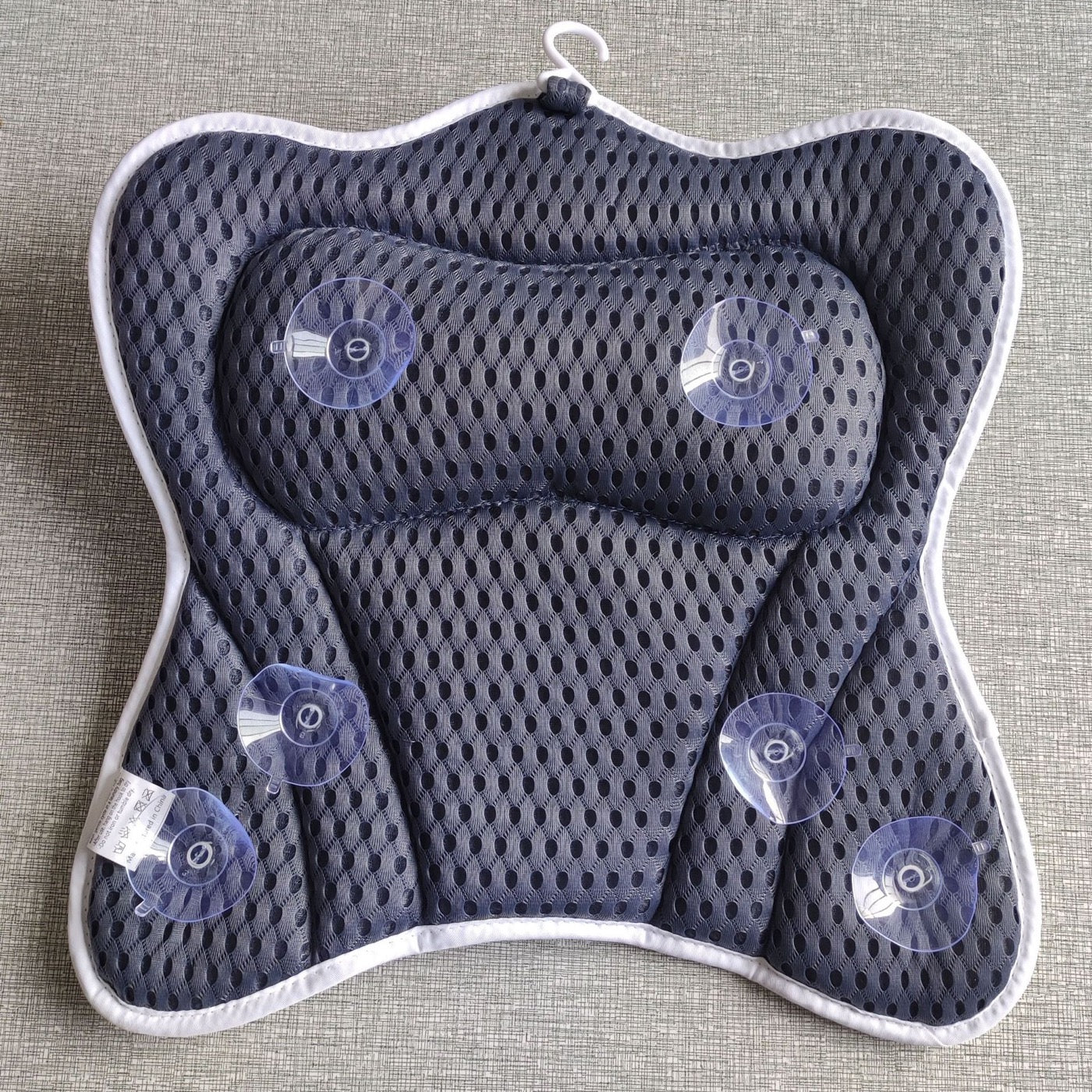 Back of the bath pillow showing the 6 suction cups that anchor it to a smooth bathtub surface.